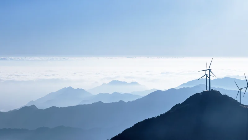 AdobeStock_123309203-wind-mills-mountains-blue-sky copy