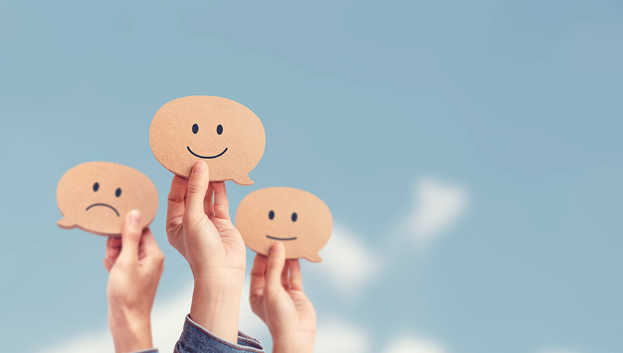 shutterstock_1687468018-people-holding-signs-of-smileys_900x510